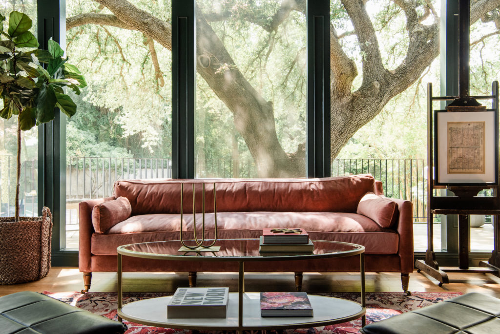 pink velvet sofa with antique easel and modern coffee table
