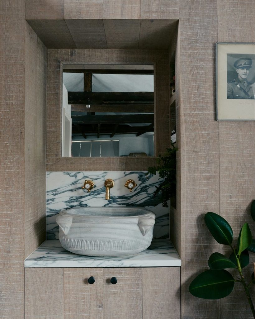 the bathroom sink in antique stone and marble reflects the wabi-sabi elegance