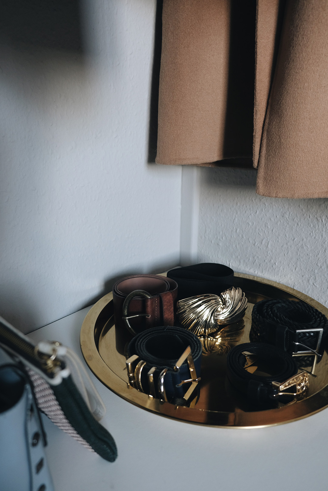 small space closet organization: belts in a brass tray