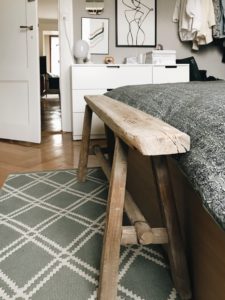 antique wooden bench at the end of the bed