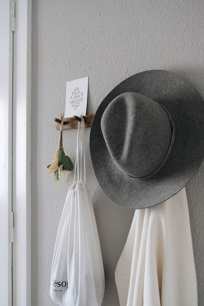 a hat on a peg rail with dried bouquet