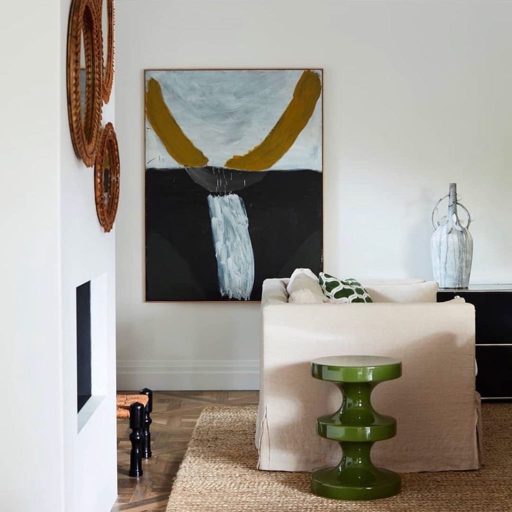 glossy side table with linen sofa and sisal rug