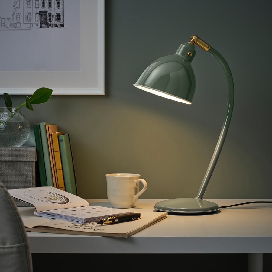 RÖDFLIK grey-green desk lamp styled on a desk