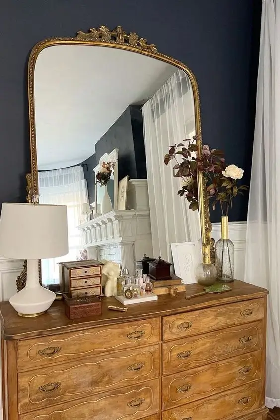 antique mirror above dresser in bedroom